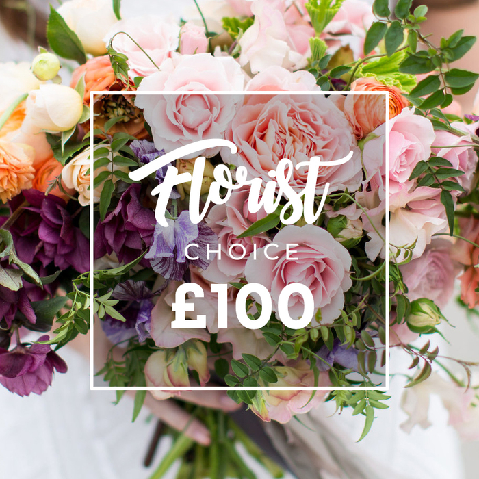 A richly textured, garden-style bouquet is presented in a close crop that celebrates colour and craft: large, full garden roses in tender pinks and blush draw the eye, their ruffled centers layered with petals like soft silk. Around them, sumptuous plum-toned hellebore-like flowers and darker magenta accents add contrast and sculptural depth, while delicate purple-and-white sweet peas drift between blooms with a breezy, fragrant presence. Soft peach and coral ranunculus or similar layered flowers introduce warm highlights, balanced by creamy white filler blossoms that lend brightness and detail. Lush greenery - slender viney stems, eucalyptus-like sprays and broader leaves - is artfully interspersed to produce a loose, organic silhouette that feels freshly gathered from a suburban cutting garden. A clean white rectangular overlay sits centrally across the bouquet, the script reading Florist Choice, with CHOICE in smaller block capitals beneath and a prominent ?100 at the bottom of the frame, clearly signalling the curated price. Gentle, diffused lighting emphasizes petal texture and the bouquet's romantic scent, while a pair of hands supports the stems at the lower edge; a faint pale sleeve is visible and the wearer's clothing is softly out of focus so the flowers remain front and centre. This image suggests a lovingly created gift, perfect for celebrating moments in Chessington - whether delivered near Chessington World of Adventures, the local shopping area, or to homes toward Hook and Malden - and is the kind of florist-selected arrangement Chessington Flowers might prepare for anniversaries or special occasions.
