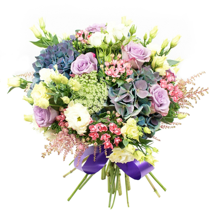 Bursting with a symphony of purple, blue, white, and gentle green, this lush bouquet by Chessington Flowers brings together the artistry and heart of our local florists. Nestled against a snowy white background, the composition is anchored by hydrangeas in velvety indigo and teal-each clustered bloom layered with plush petals that evoke the richness of woodland walks in Chessington's countryside. Fragrant roses in soft lilac and classic creamy white unfurl serenely amid tightly spun ranunculus, whose ruffled white layers offer texture and depth. Throughout, pale yellow-green lisianthus buds and blossoms reach upward, lending height and a whisper of freshness akin to early morning mist near Chessington's parks. Sprays of vibrant fuchsia-pink filler flowers and feathery pale astilbe plumes spill over the edges, their dynamic hues adding youthful energy and charisma. Delicate, almost translucent Queen Anne's Lace or Ammi Majus intertwines among the arrangement, bringing a touch of the wild English garden aesthetic. Carefully placed rich green foliage supports and sets off the vibrant blooms, ensuring their colours truly sing. Tied at the base, a wide royal purple satin ribbon finishes the bouquet with a luxurious flourish, perfectly balancing the cool palette and repeating the underlying theme of sophistication. This bouquet embodies joy, luxury, and romance-created with an eye for detail and an understanding of Chessington's unique local tastes, ideal for birthdays, anniversaries, or simply elevating home décor. For those seeking an impressive floral statement delivered in and around Chessington, this arrangement stands as a beautiful testament to local craftsmanship.